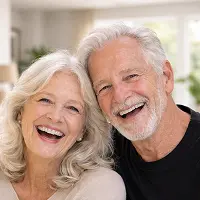 Ein lächelndes älteres Ehepaar mit weißen Haaren posiert eng beieinander in einem Innenraum und sieht glücklich und entspannt aus, vielleicht nach einem Gespräch über eine Immobilien Schenkung mit einem Notar in Berlin, mit natürlichem Licht im Hintergrund.